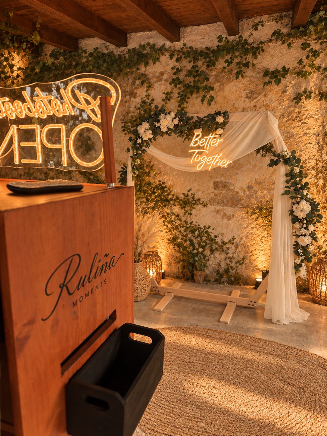 Arco decorativo con neón Better Together y luces cálidas junto al fotomatón · Ruliña Moments
